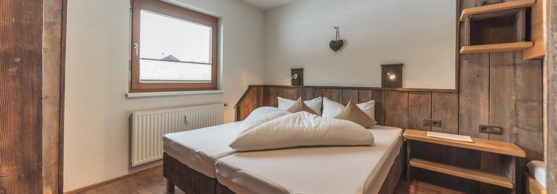 Schlafzimmer - Ferienwohnungen Rustica - Huben