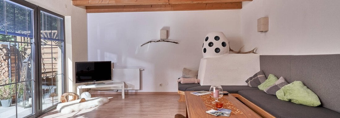 gemütlicher Wohnbereich mit Bauernofen - Appartement Alpenea - Längenfeld