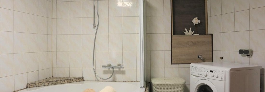 Badezimmer Eckbadewanne und Waschmaschine - Ferienwohnung Lenz - Sautens